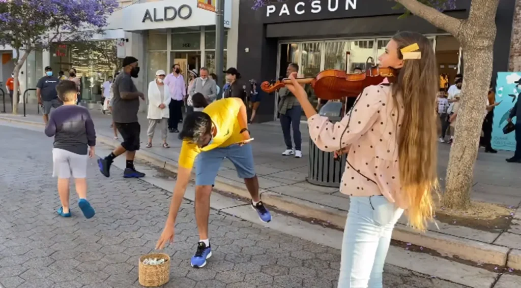 Street violin, Street Performer, Violin Performance, Urban Music Scene, Karolina Protsenko, City Street Entertainment, Outdoor Music Experience, Cultural Diversity in Music, Post-Pandemic Performances, Supporting Street Artists, Musical Inspiration in Public Spaces