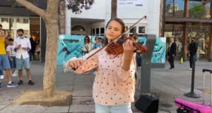 Street violin, Street Performer, Violin Performance, Urban Music Scene, Karolina Protsenko, City Street Entertainment, Outdoor Music Experience, Cultural Diversity in Music, Post-Pandemic Performances, Supporting Street Artists, Musical Inspiration in Public Spaces
