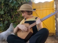Phoebe’s music video, fretless banjo, charming chicken, Down in the River to Pray, authenticity, whimsical, homely vibe, heartfelt performance, simplicity, nostalgia.