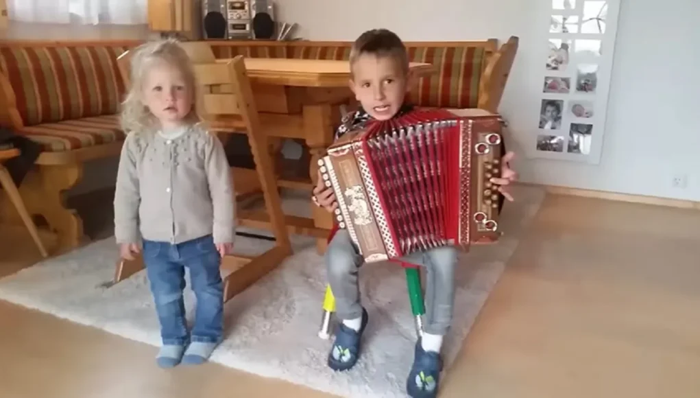 Young accordion player, Sibling bond through music, Children's musical talent, Accordion music magic, Dance inspired by music, Kids and musical instruments, Childhood musical moments, Family music stories, Magical childhood memories, Accordion melodies and dance